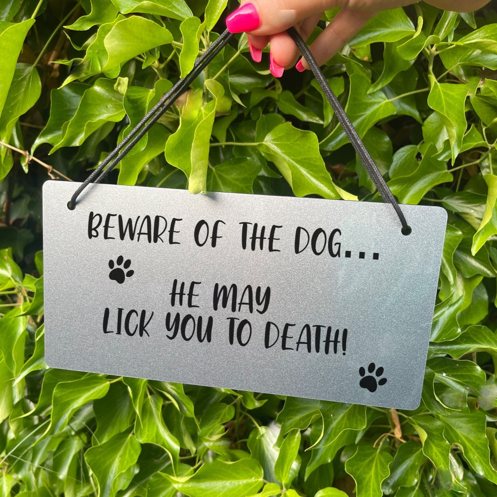 Crafted from durable acrylic, this sign is skillfully laser-engraved with the message: 'Beware Of The Dog - He May Lick You To Death'. Shining in your choice of gold or silver, this sign is not only a statement piece but also a source of smiles for anyone who encounters it. A delightful addition that brings humor and character to your surroundings.