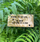 An acrylic sign featuring laser-engraved text reads: 'Beware Of The Dog - He May Lick You To Death'. This durable sign is available in either gold or silver. It serves as a charming and humorous addition to your space, guaranteed to leave a lasting impression on visitors and evoke smiles.