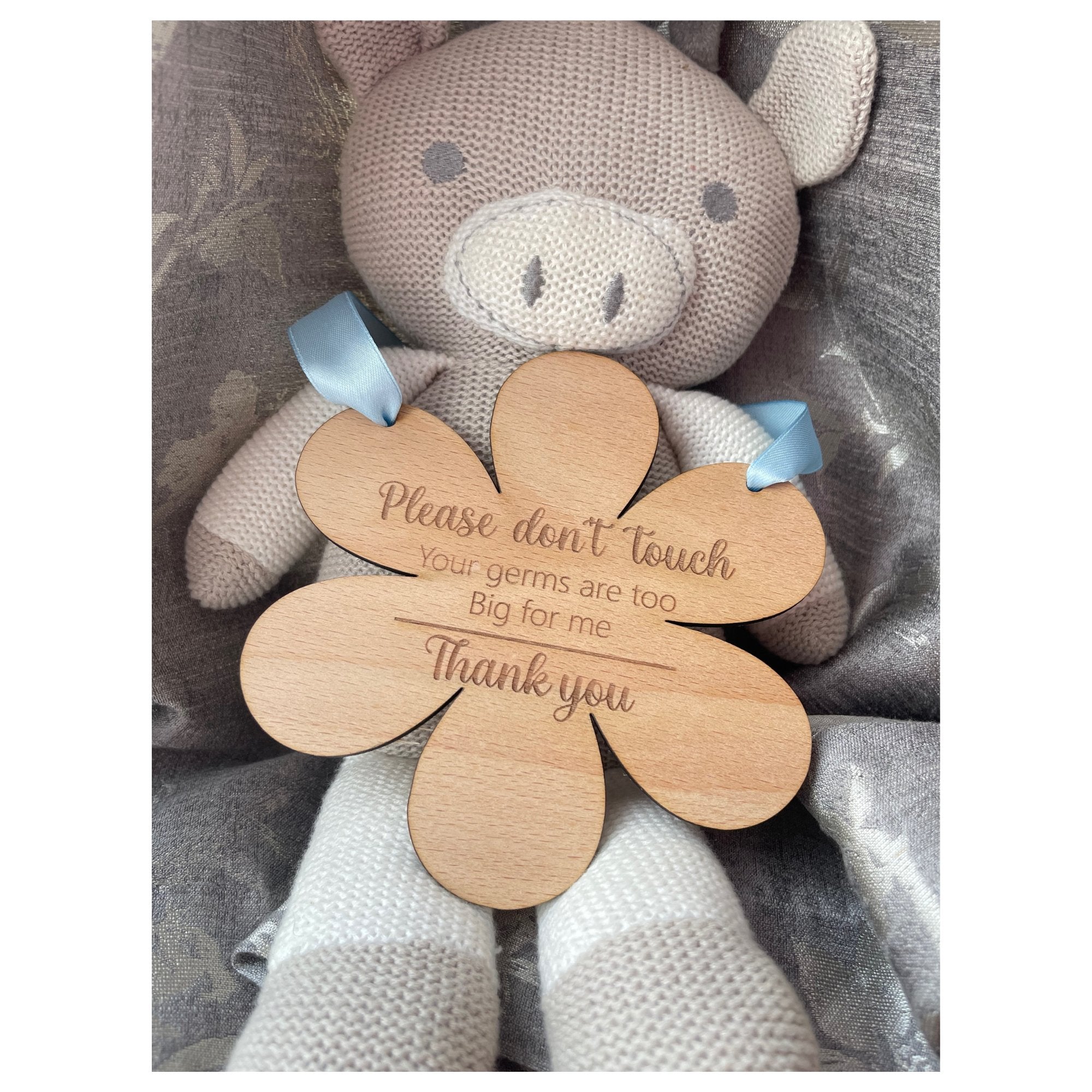Cherish the joys of motherhood while ensuring your baby's safety with our flower-shaped beech wood hanging sign. Measuring 145mm by 148mm and crafted from durable 4mm wood, this enchanting piece serves as a protective shield. Personalized with 'Please do not touch, your germs are too big for me, thank you,' and your choice of a blue or pink ribbon.