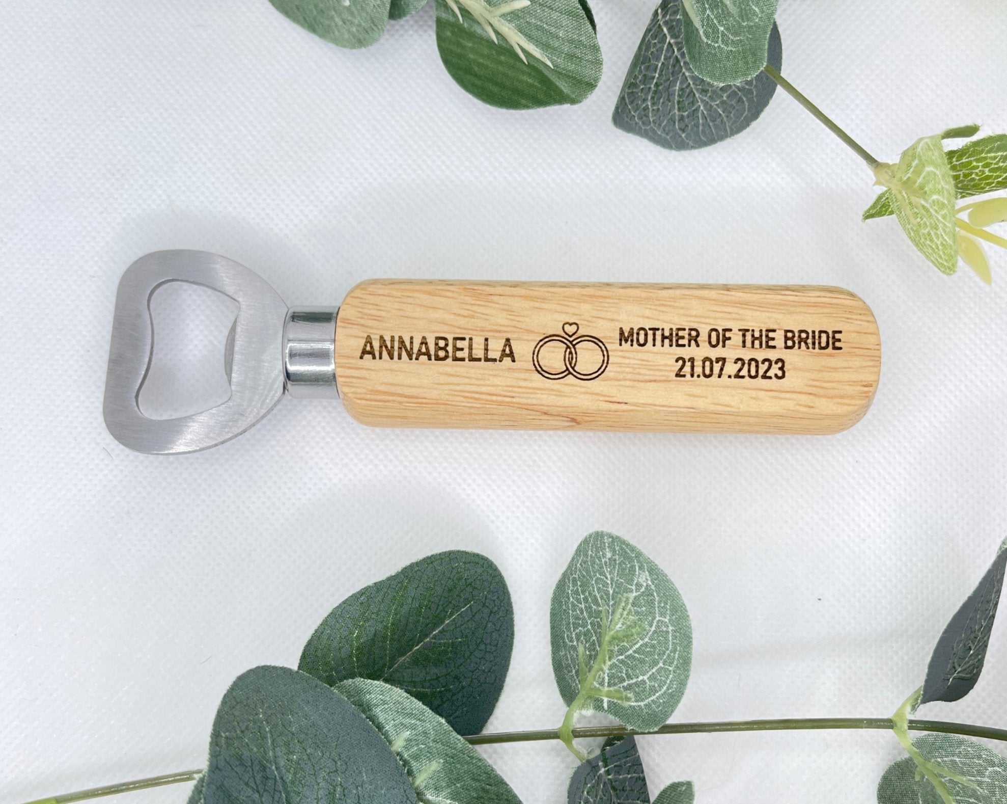 Bottle opener personalise with name at the left hand side, right role of wedding & date under. in the middle there is a picture of two rings & a heart on top. Perfect for wedding gifts. Bridesmaids with a girly touch.   