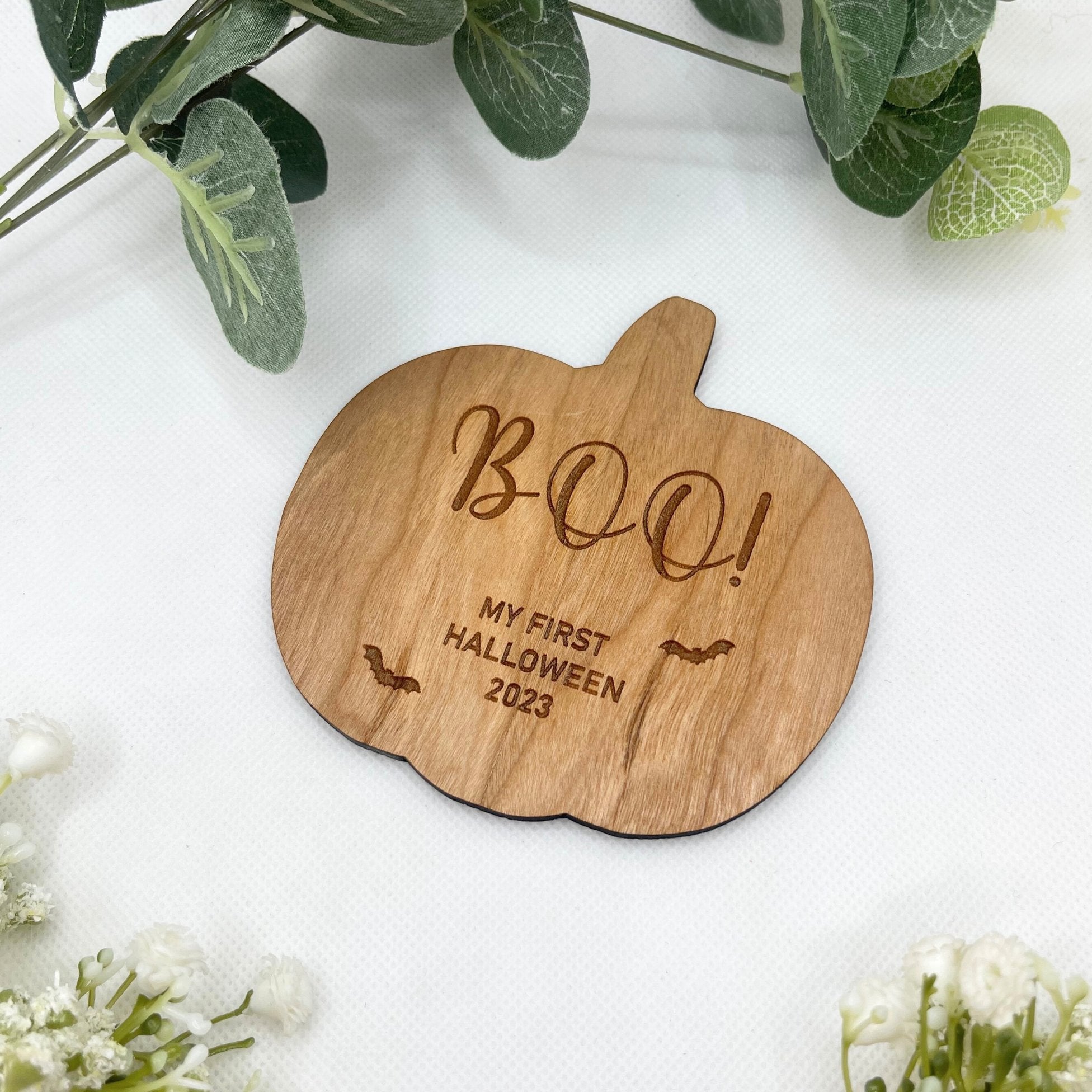 Introducing our charming 'Boo! My First Halloween' pumpkin-shaped plaque – a personalized keepsake crafted from cherry wood, adorned with delightful bats. Capture the magic of your baby's first Halloween in style!