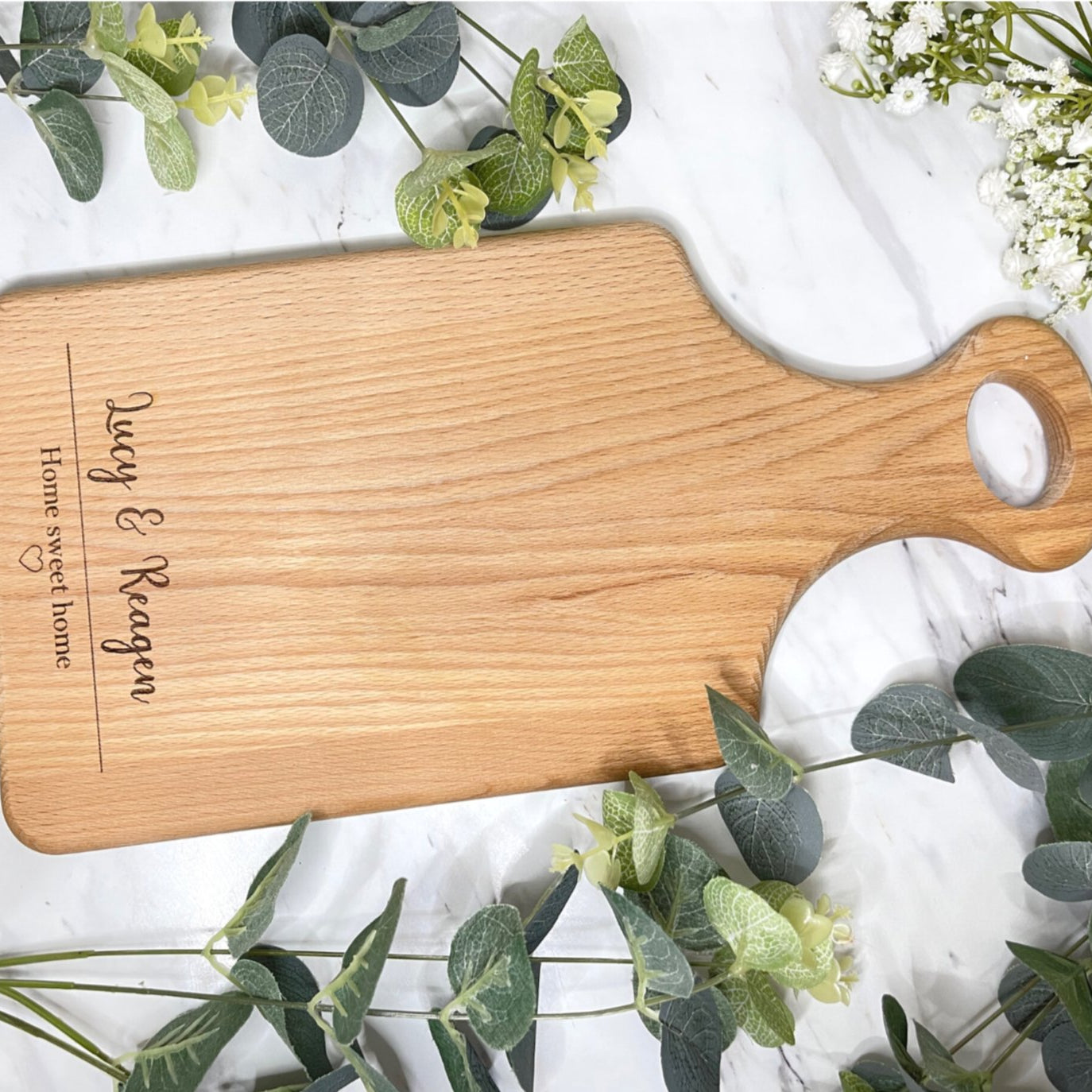 Exquisite wooden serving board, meticulously personalized with the endearing inscription 'Home Sweet Home' encircled by an intricately etched heart motif. An impeccable gift choice to celebrate housewarmings, weddings, anniversaries, birthdays, or expressions of gratitude.