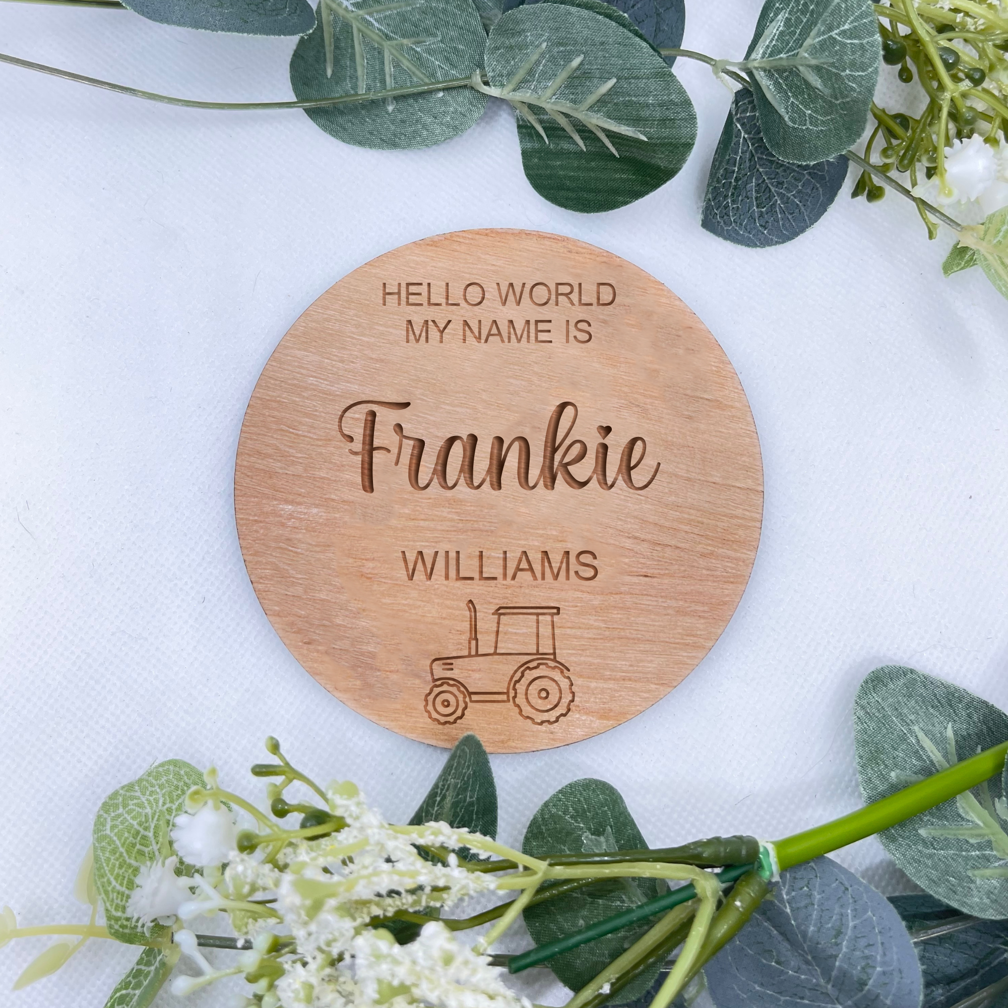 A handcrafted beech veneer baby announcement plaque with customisable text, adorned with a cute tractor design, making it a timeless keepsake for new parents.