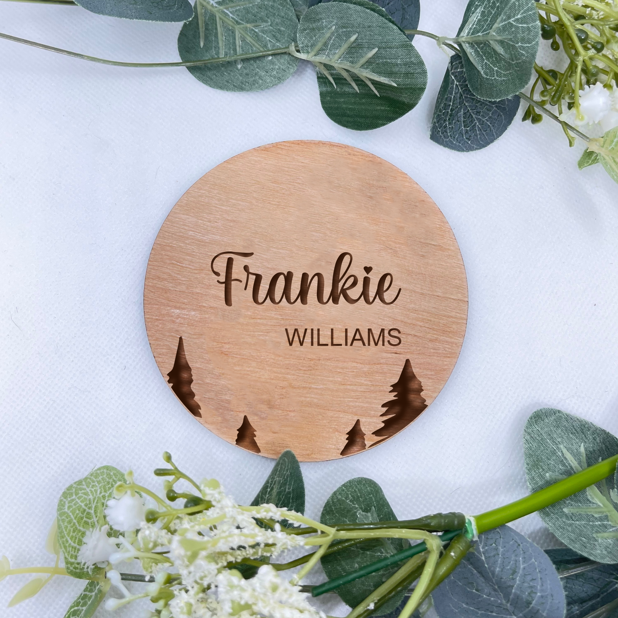 A round personalised baby announcement plaque with a delicate tree design, crafted from premium beech veneer, showcasing the baby's first and last names in elegant script.