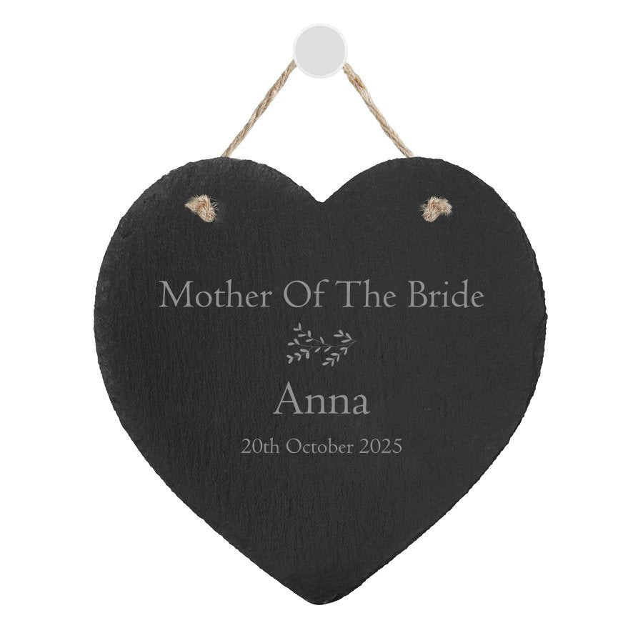 A hand-cut, heart-shaped slate plaque with a natural hanging rope, featuring a personalized engraving with a heart motif. This elegant plaque, measuring approximately 15cm by 15cm, offers a unique and rustic charm with variations in cut, texture, and pattern. Perfect as a thank you gift for the mother of the bride or groom, maid of honor, or bridesmaids, it can include the recipient's name, role in the wedding, and the date.