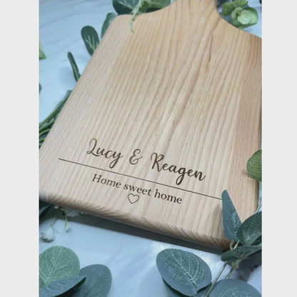 Skillfully crafted personalized serving board, featuring an elegant display of the phrase 'Home Sweet Home' intertwined with a delicately designed heart emblem. A truly thoughtful and distinctive present suitable for a range of significant occasions.