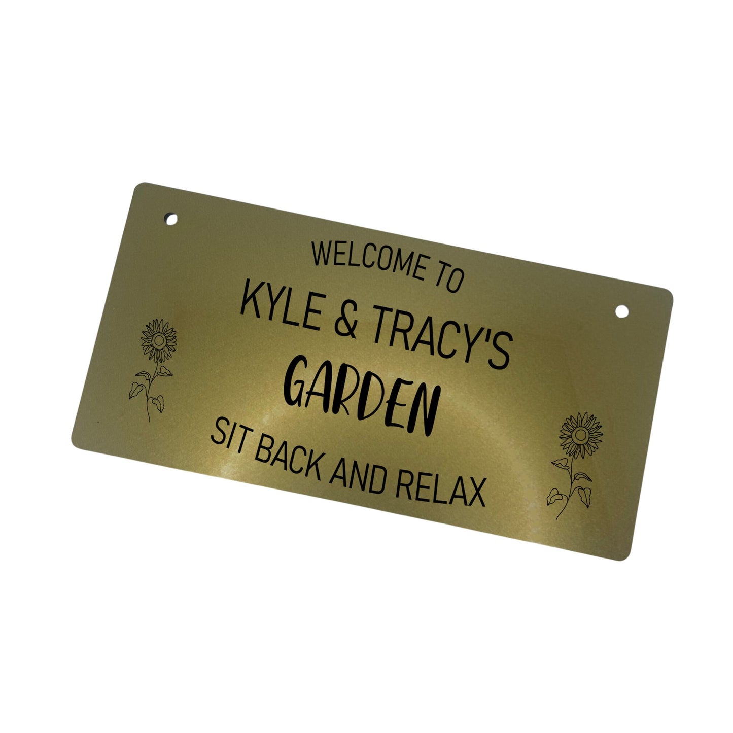 Alt text: Personalised Garden Sign - Gold Acrylic Description: A charming personalized garden sign crafted from 3mm thick acrylic in a beautiful gold finish. The sign features engraved text "Welcome to [Your Name's] Garden" at the top, "Garden" in the middle, and "Sit Back and Relax" at the bottom. Enhanced with two laser-engraved sunflowers. Comes with two 5mm holes and black twine for easy hanging.