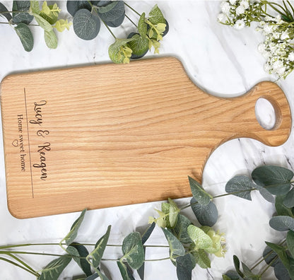 Exquisite wooden serving board, meticulously personalized with the endearing inscription 'Home Sweet Home' encircled by an intricately etched heart motif. An impeccable gift choice to celebrate housewarmings, weddings, anniversaries, birthdays, or expressions of gratitude.