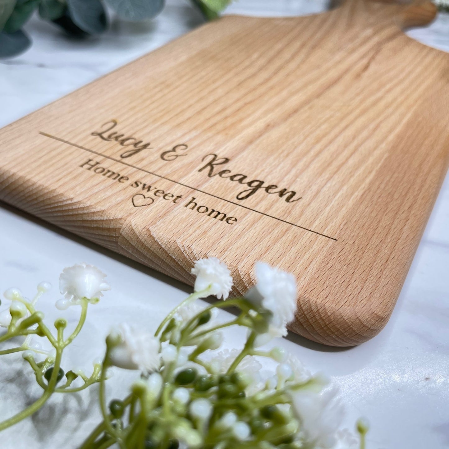 Artfully designed serving board, bearing a custom touch with the phrase 'Home Sweet Home' artistically intertwined with a heart illustration. Ideal for gifting on weddings, anniversaries, birthdays, or any heartfelt moment deserving remembrance.
