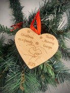 Personalized Wooden Heart Christmas Bauble: Cherish memories with our heart-shaped beech veneer ornament. Engraved '1st Christmas as a Family' with names, featuring intertwined hands, year, and a red ribbon. A heartfelt addition to your festive decor.